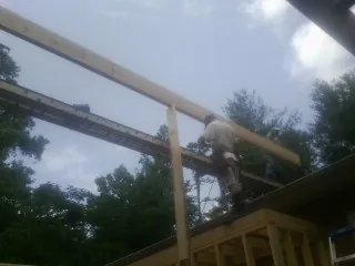 Carpenter setting a ridge beam over a new addition frame — Ice Dam Removal by Roofing Brothers in Hartford City
