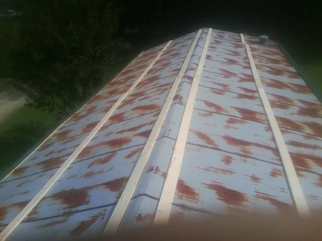 Rusted metal roof panels with new wood purlins before replacement — Storm Damage Roof Repair in Hartford City by Roofing Brothers