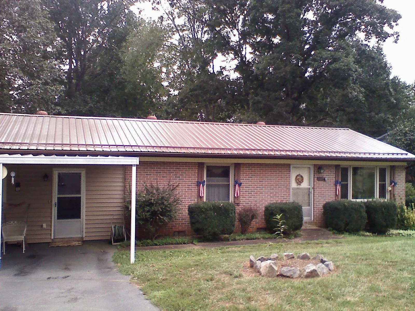 Bronze metal roof and carport on a brick ranch home — Roof Repair work by our crew in Hartford City